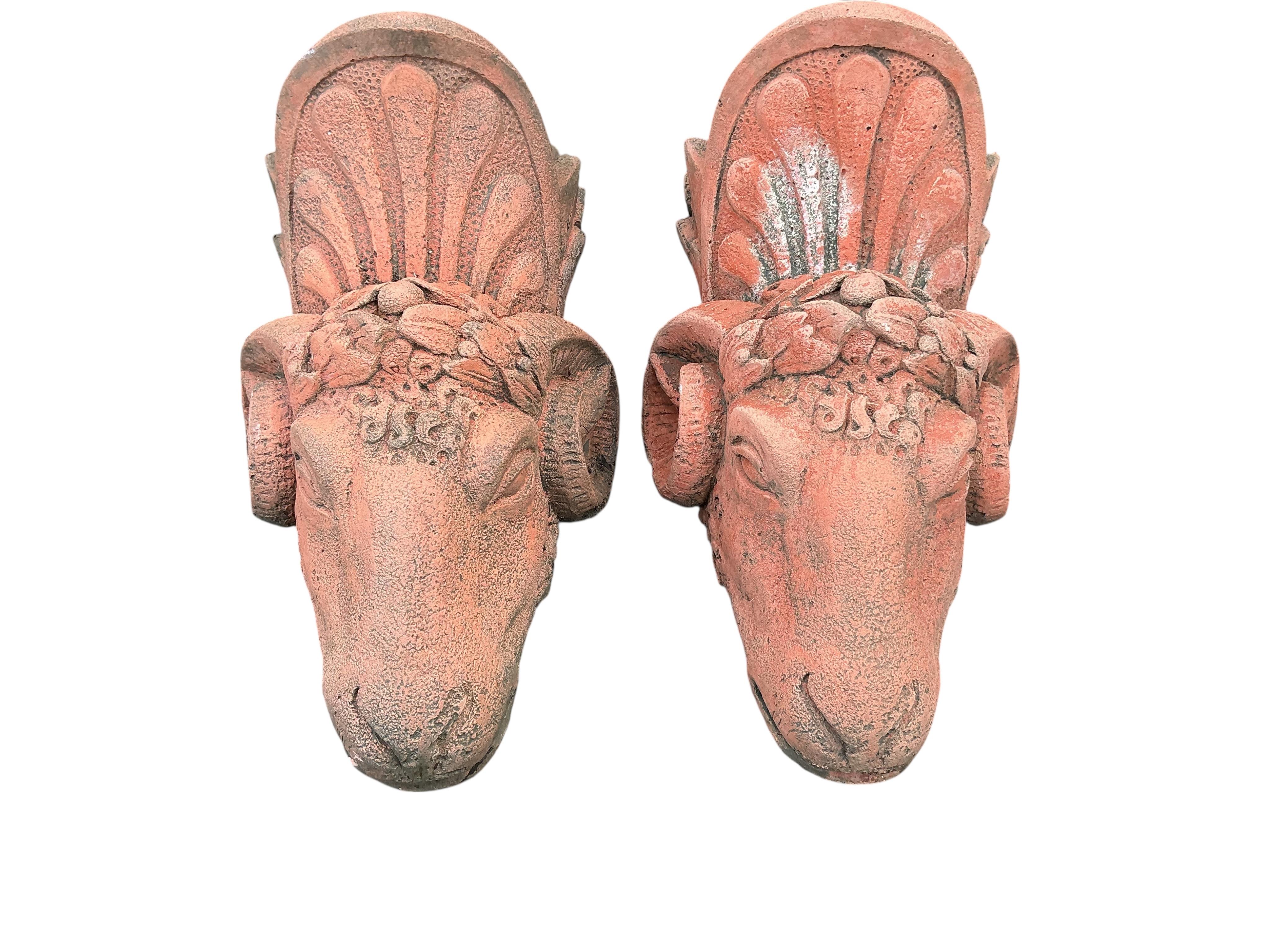 A pair of terracotta ram's head wall pockets, height 42cm